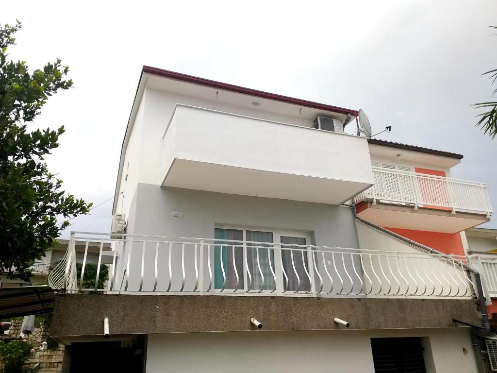 a white building with a balcony with surfboards on it at Villa Dora ##3 in Crikvenica