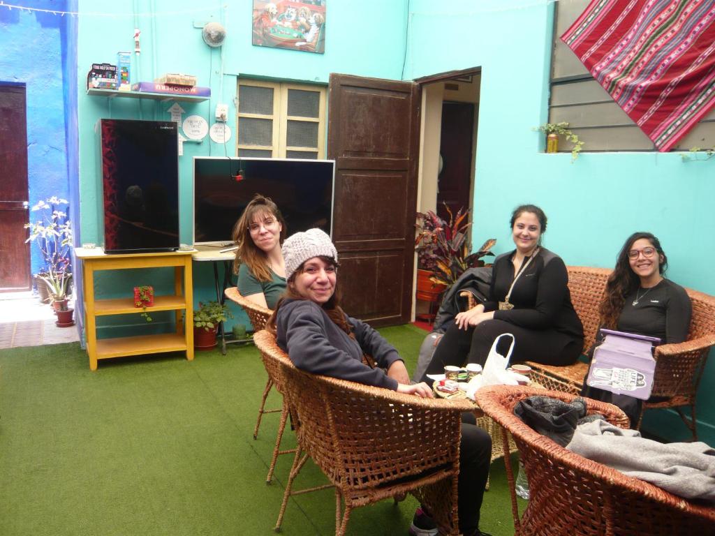 un grupo de mujeres sentadas alrededor de una mesa en una habitación en Hostel Fuentes, en Arequipa