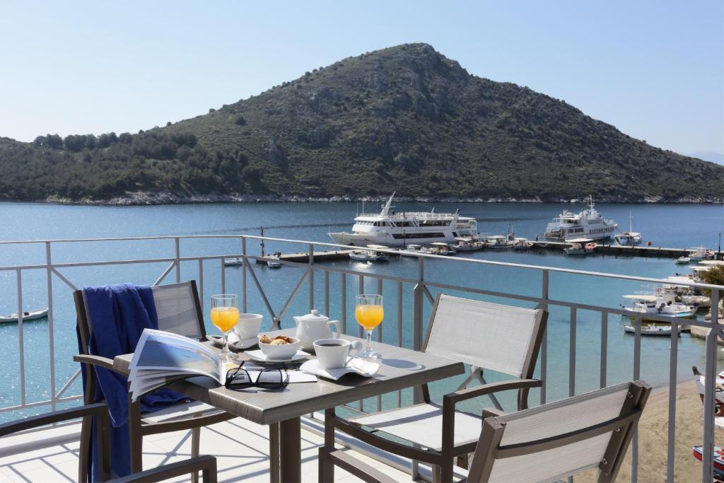 a table with two chairs and a view of the water at Hotel Aktaion in Tolo