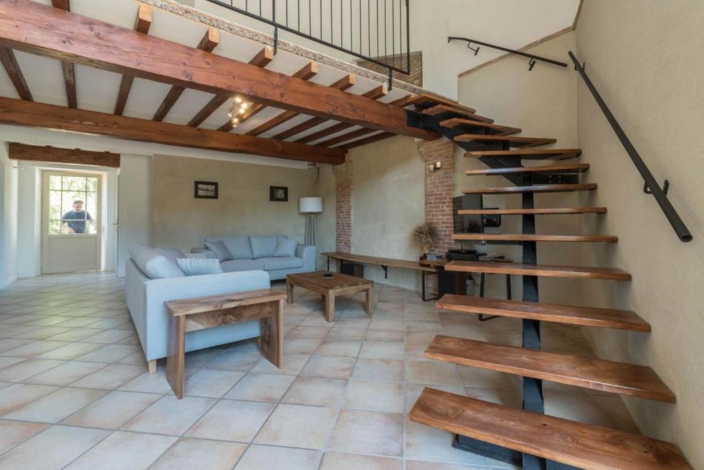 Gardouch的住宿－gite de la gasignole，客厅设有螺旋楼梯和沙发