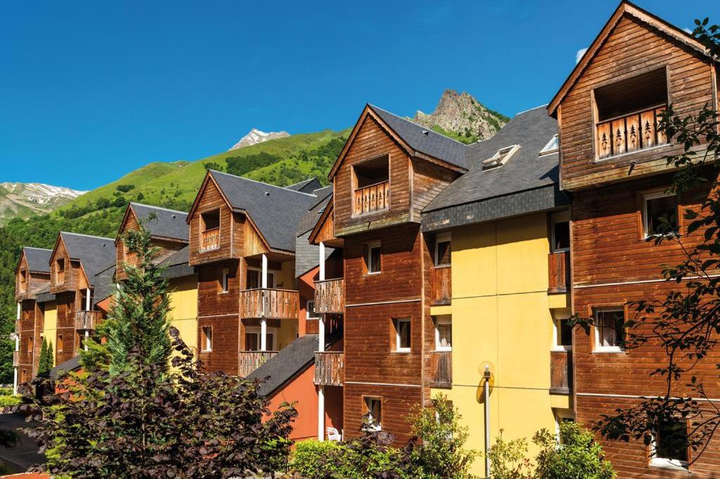 a group of houses with mountains in the background at T2 RESIDENCE 3 ETOILES Piscine chauffée Sauna Hammam in Cauterets