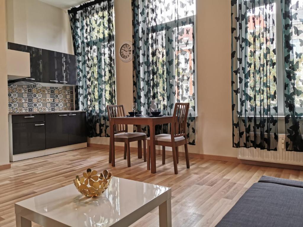 Una sala de estar con una mesa y sillas y un televisor. en Cosy Europarlament apartment, en Bruselas