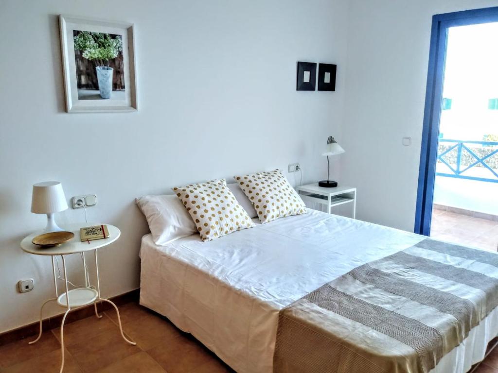 biała sypialnia z dużym łóżkiem i oknem w obiekcie Villa la 29 w mieście Playa Blanca