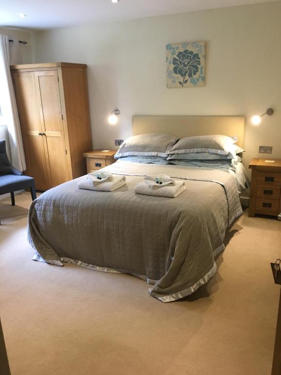 a bedroom with a bed with two towels on it at Bryn Derwen in Rhayader
