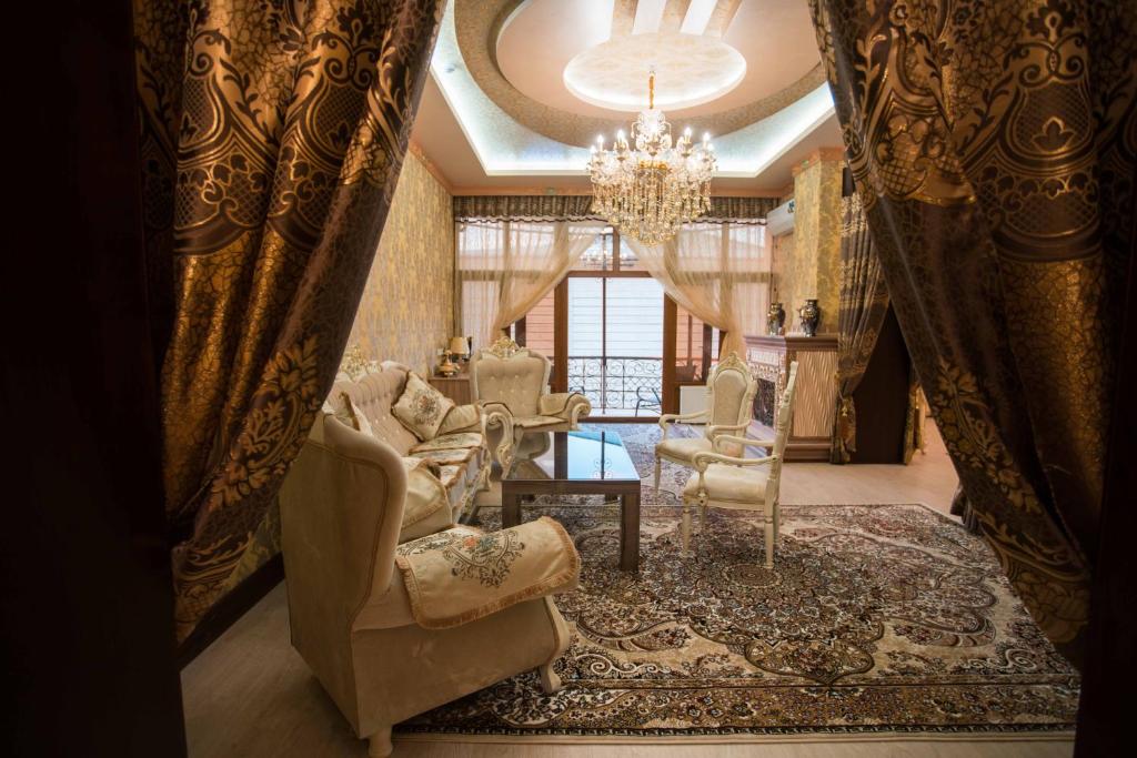 a living room with chairs and a chandelier at Caravan Castle Boutique Hotel in Bukhara