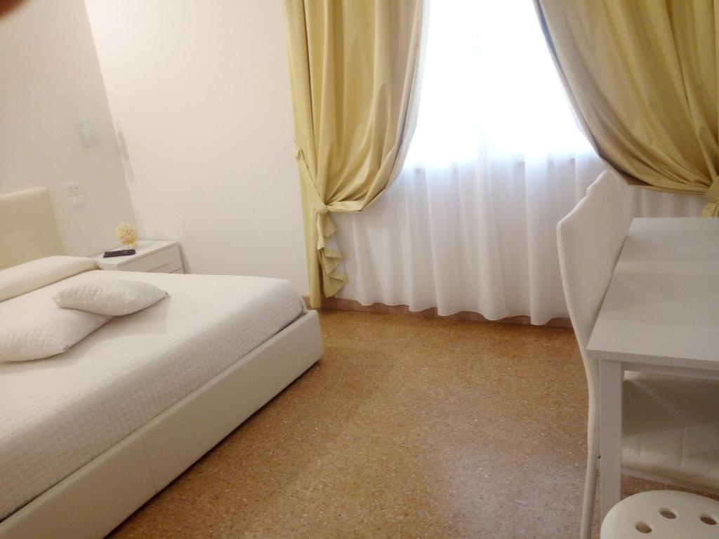 - une petite chambre avec un lit blanc et une fenêtre dans l'établissement Officina Urban Sleep, à San Benedetto del Tronto