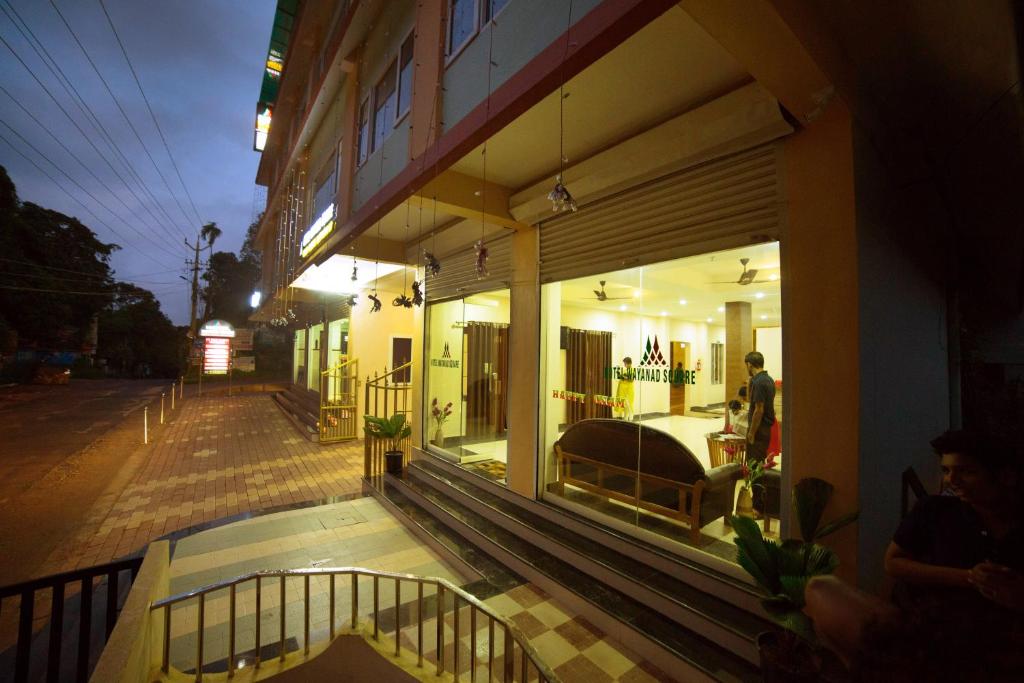 una tienda frente a un edificio por la noche en Hotel Wayanad Square, en Mananthavady