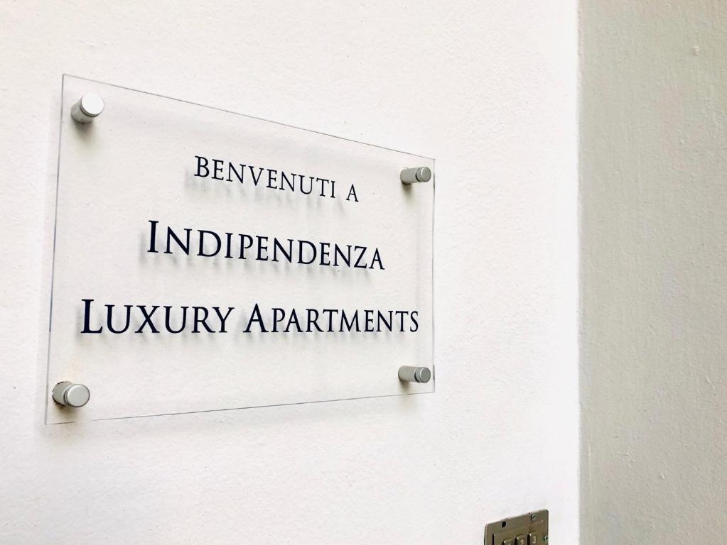 un letrero en una puerta blanca con las palabras debajo de los solicitantes involuntarios en Indipendenza Luxury Apartments, en Bolonia