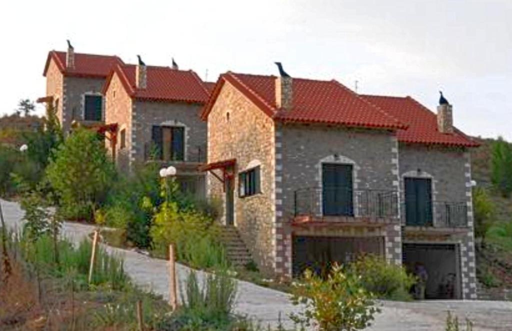 a large brick house with a red roof at All Seasons Πέτρινες Παραδοσιακές Κατοικίες in Kalavrita