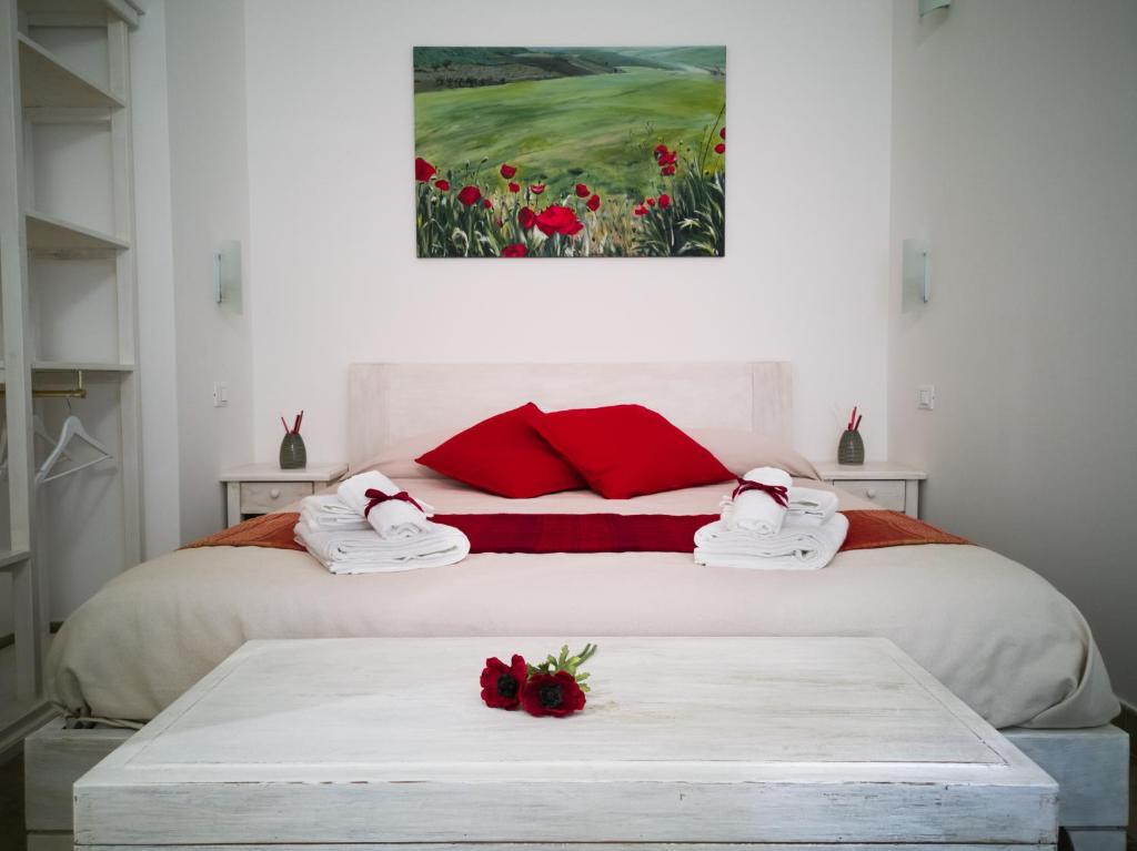 a bedroom with a bed with red pillows and a painting at Etesia Vacation Home in Acitrezza