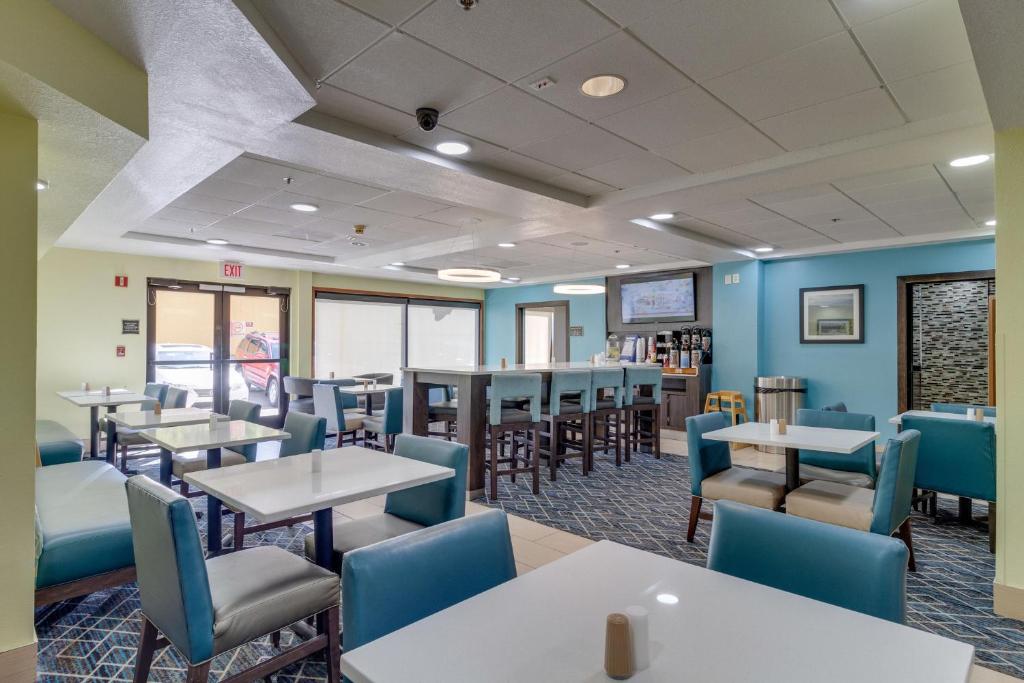 a dining room with tables and blue chairs at La Quinta by Wyndham Sevierville / Kodak in Sevierville