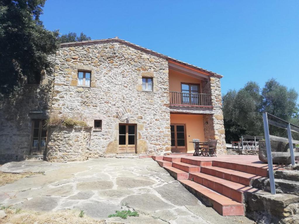 - une vue extérieure sur une maison en pierre avec des escaliers dans l'établissement Casa Rural Can Met, à Llorá