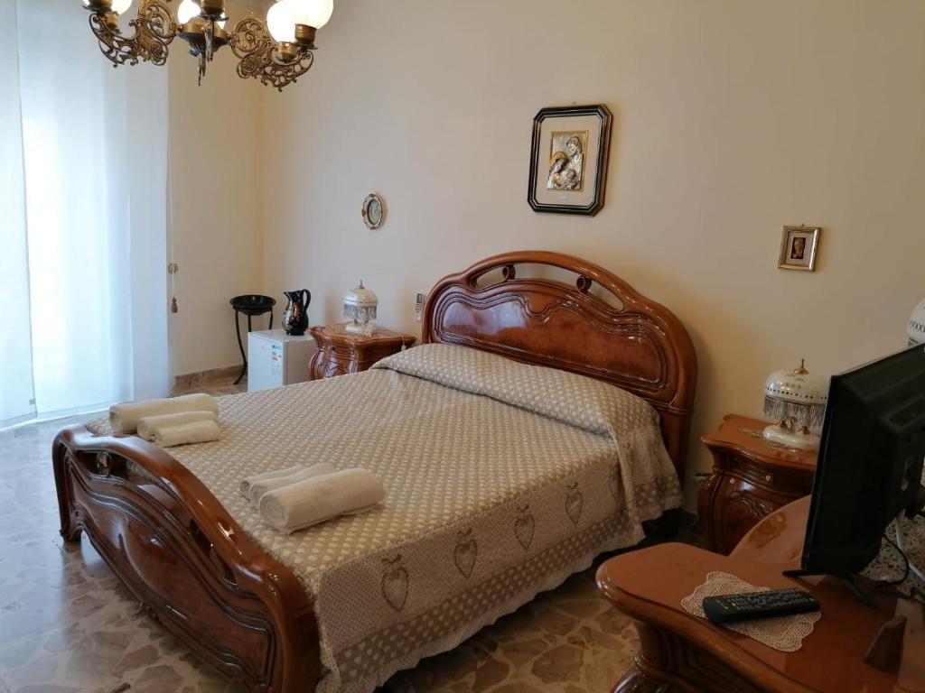 1 dormitorio con cama de madera y toallas en San Caloiru Home, en Naro