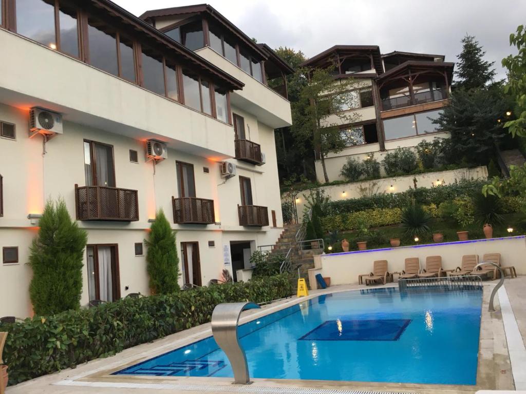 a hotel with a swimming pool in front of a building at Sapanca Dilek Konagi Hotel in Sapanca