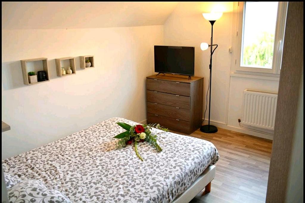 a bedroom with a bed and a dresser at À 10 minutes de voiture d'Étretat in Les Loges