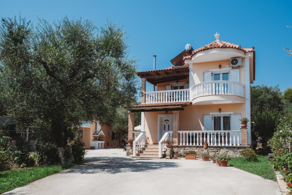 a large house with a balcony and a driveway at Villa Rosa 3 Bedroom with Sea View in Tragaki