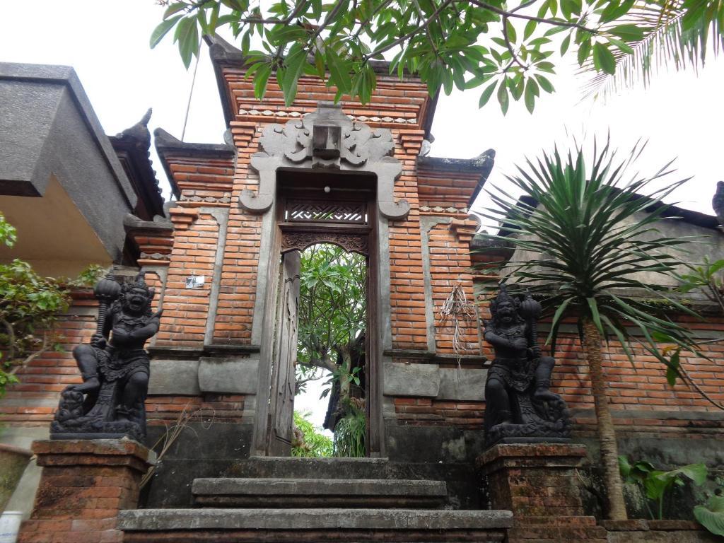 an entrance to a building with statues on the stairs at Sintya Homestay in Ubud