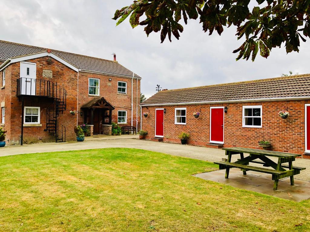 a picnic table in front of two brick buildings at Paull Holme Farm Bed and Breakfast in Paull