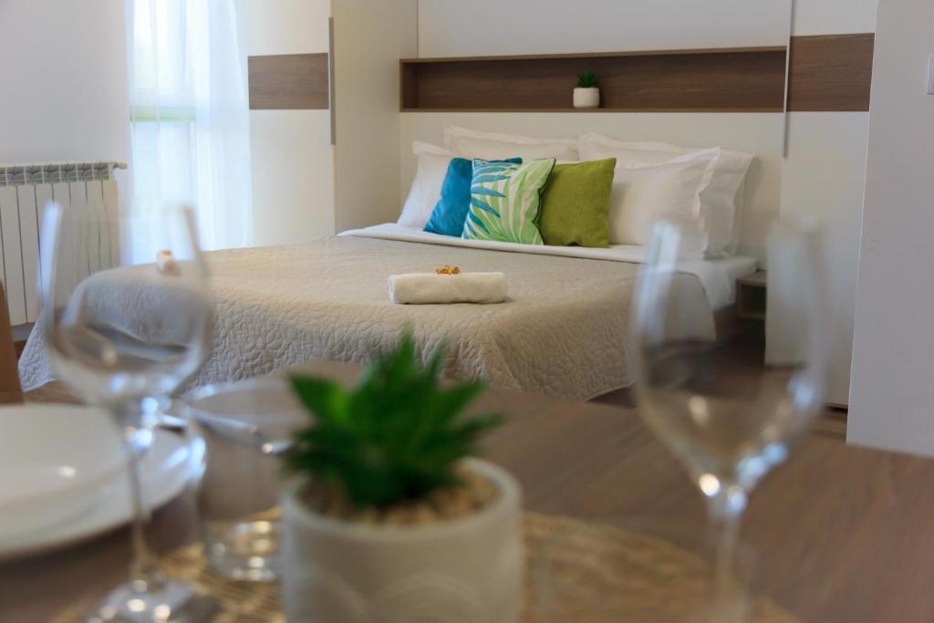Schlafzimmer mit einem Bett mit Weingläsern auf dem Tisch in der Unterkunft Gold Class Apartment AMS 63 in Cluj-Napoca