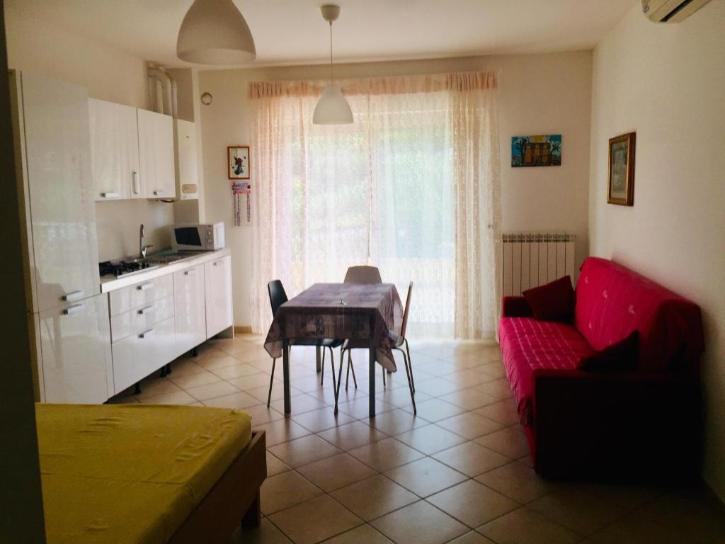 a living room with a table and a red couch at La Perla in Silvi Marina