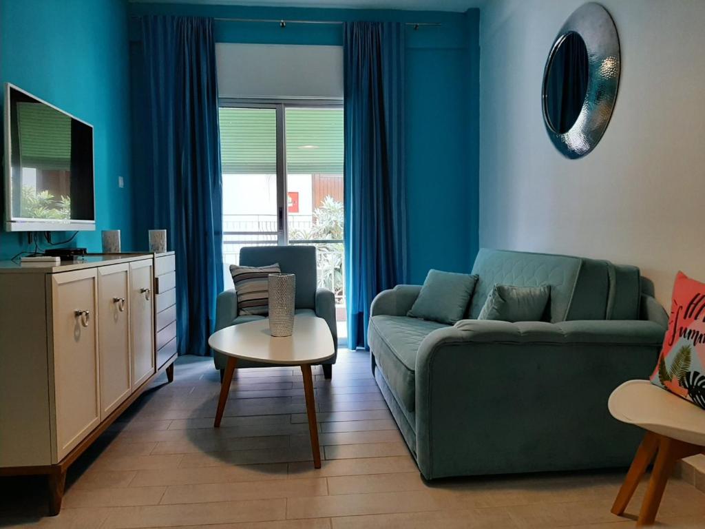 a living room with a green couch and a table at Gala Apartment in Nea Potidaea