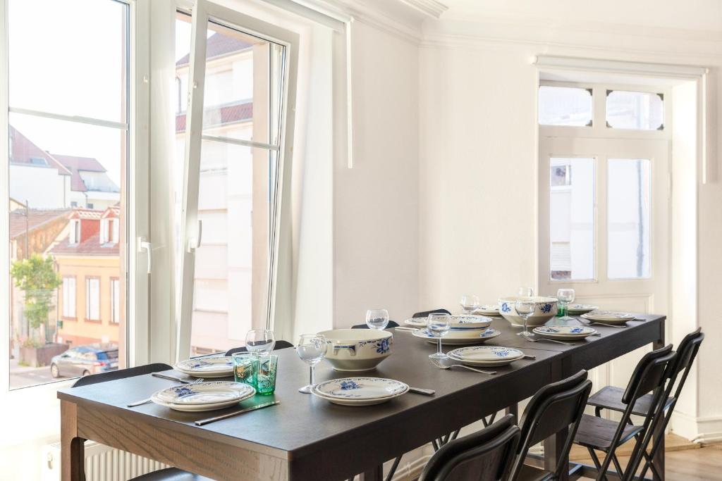 une table à manger avec des chaises et une grande fenêtre dans l'établissement Le Victor Hugo, à Colmar