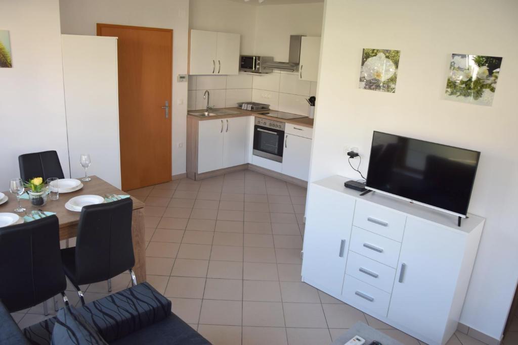a kitchen with a table and a television in a room at COMFY and BRIGHT Apartment in Kranj