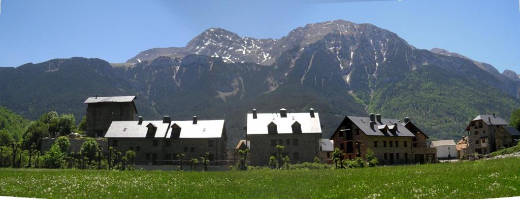 a building in a field with a mountain in the background at Apartamento Millas in San Juan de Plan