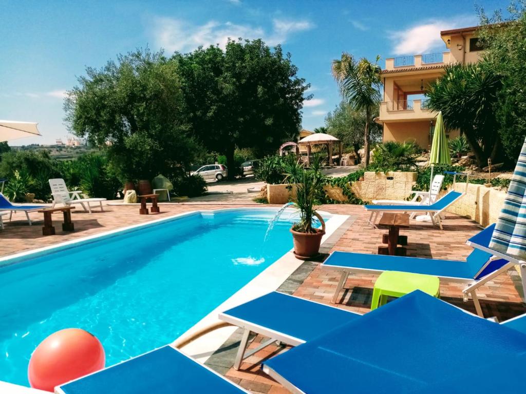 a villa with a swimming pool and patio furniture at B&B Villa Sant'Antonio in Brucoli