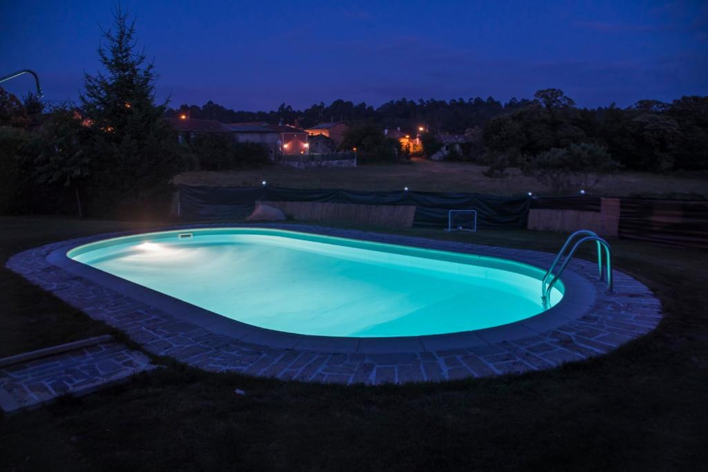 ein Schwimmbad im Hof in der Nacht in der Unterkunft Casa Rural Anxeliña in Boborás