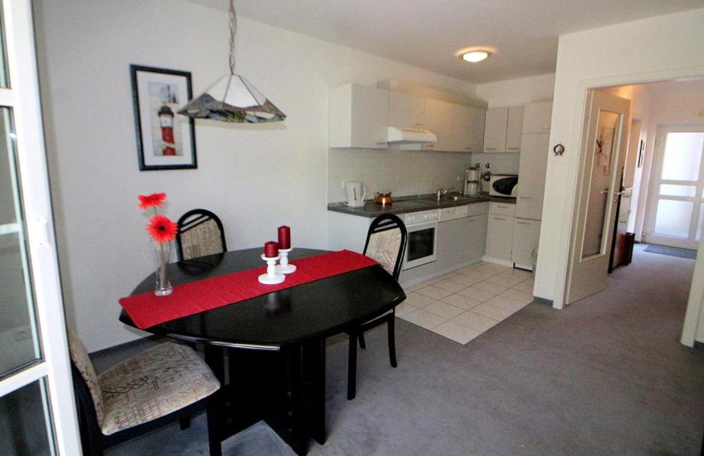 a kitchen with a table with a red table cloth at Apartmentvermittlung Mehr als Meer - Objekt 30 in Niendorf