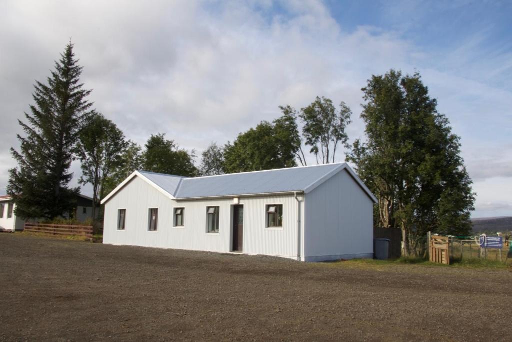 a white house with a grey roof at Finnstaðir in Egilsstaðir