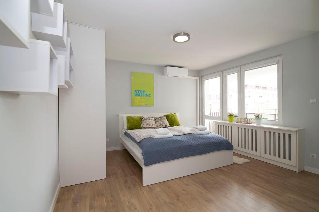 - une chambre blanche avec un lit et une fenêtre dans l'établissement WLR Apartments - Hoza II, à Varsovie