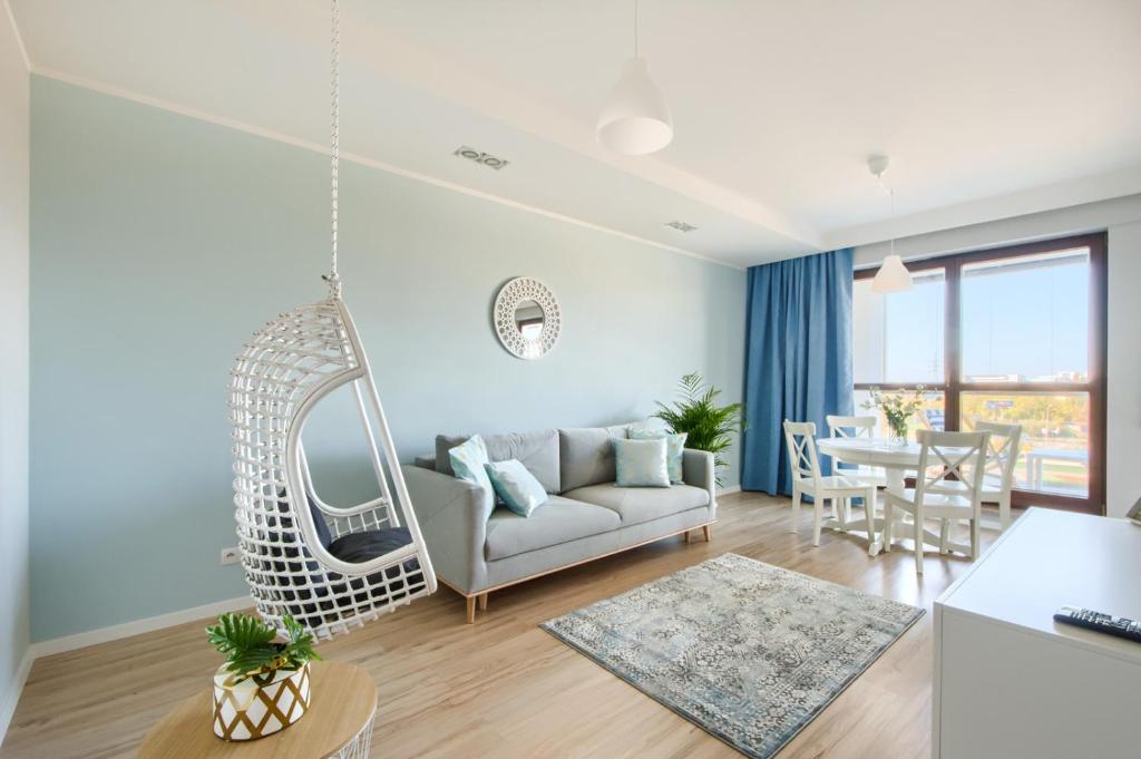 a living room with a white couch and a swing at Naviflat - West Side Apartment in Warsaw