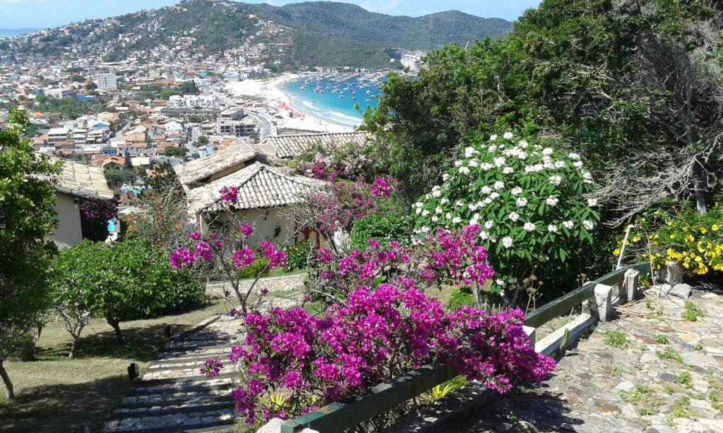 een uitzicht op een strand met paarse en witte bloemen bij Casa Pontal do Atalaia in Arraial do Cabo
