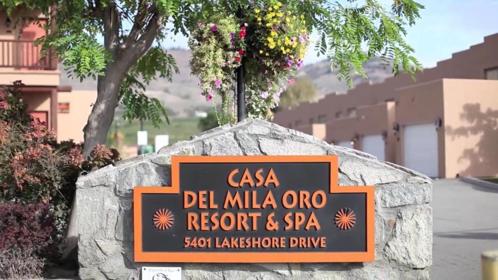 a sign for a resort and spa on a stone wall at Casa Del Mila Oro Condo in Osoyoos