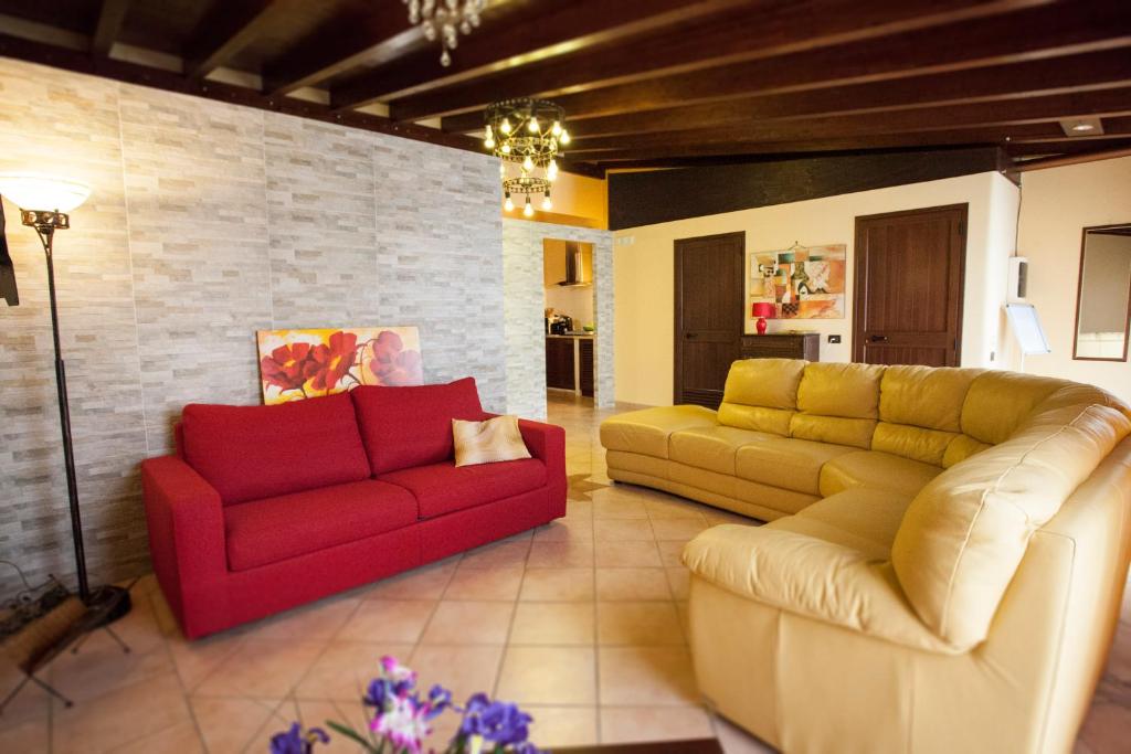 a living room with two couches and a red couch at FILANNA HOME RELAX in San Vito lo Capo