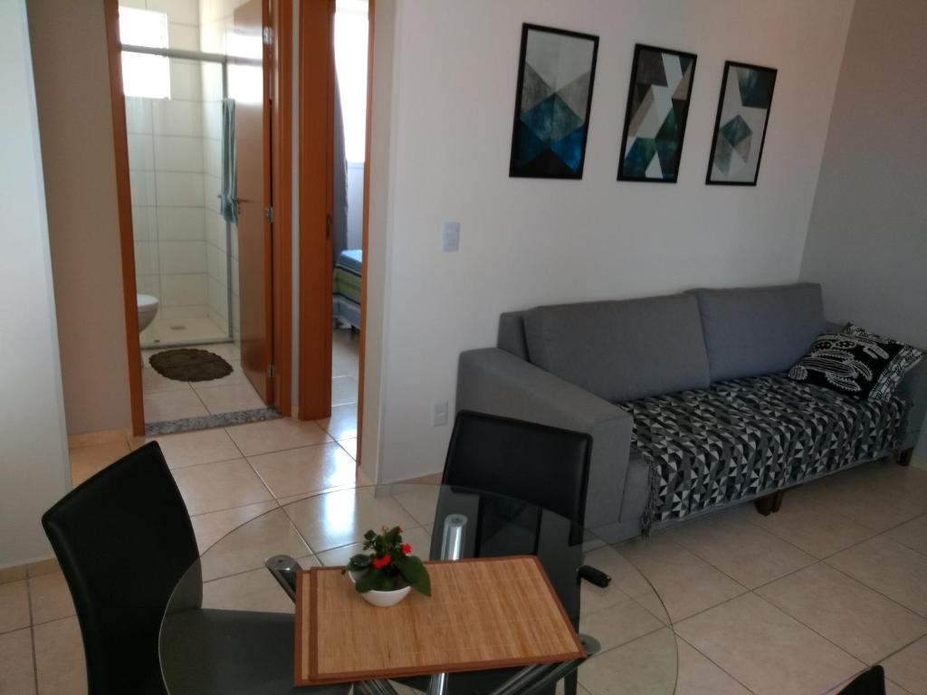 een woonkamer met een bank en een tafel bij Residencial in Belo Horizonte