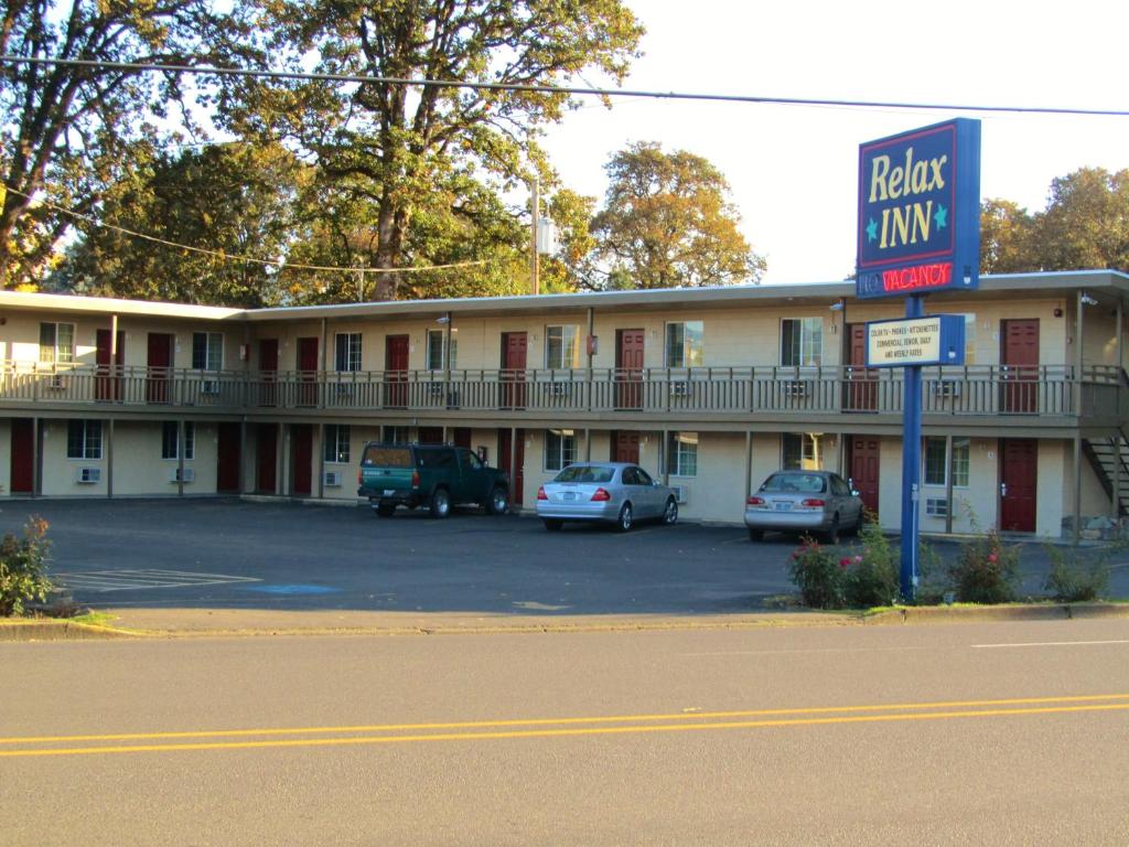 un hotel con coches estacionados en un estacionamiento en Relax Inn - Cottage Grove, en Cottage Grove