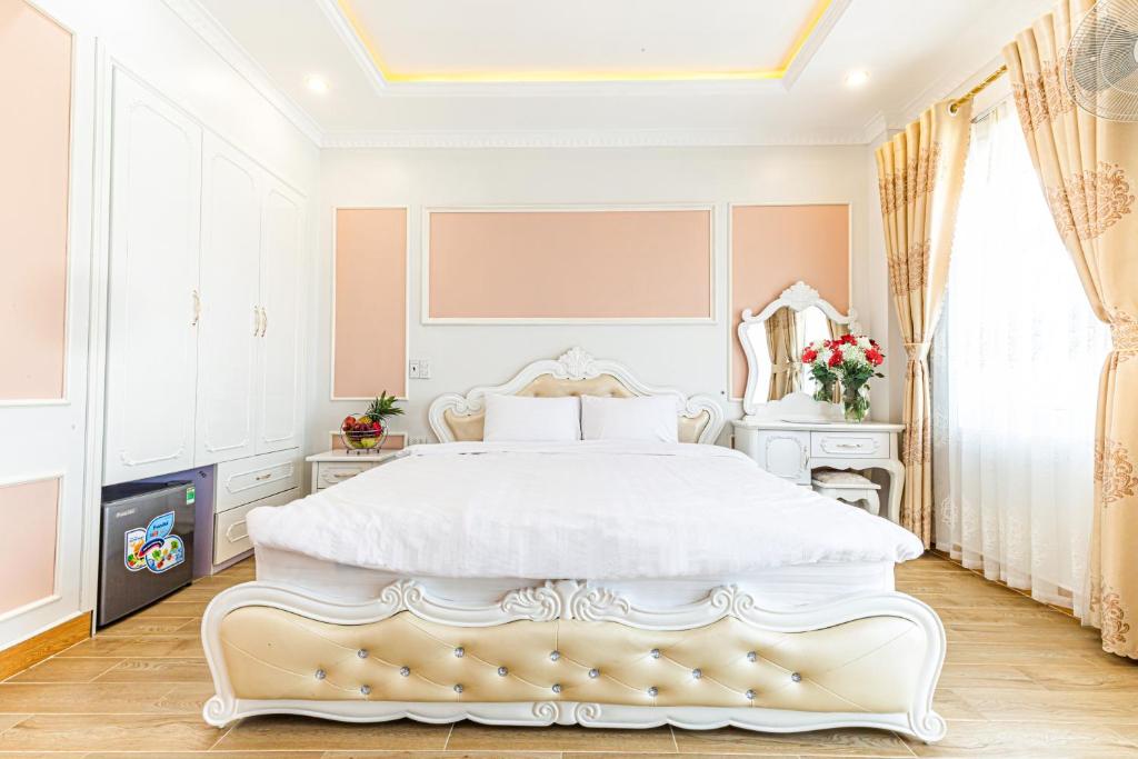 um quarto branco com uma grande cama branca e uma janela em An loc hotel em Dien Bien Phu