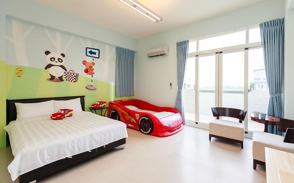 a bedroom with a bed and a red car on the wall at 童畫民宿ㄧ寵物收費無電梯 in Taitung City