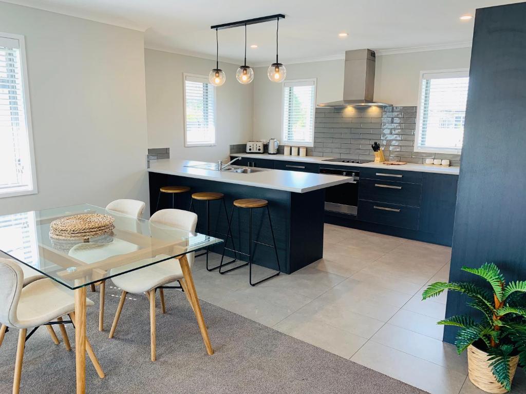 een keuken met een tafel en stoelen en een eetkamer bij Stunning Brand New Executive Home in Hastings