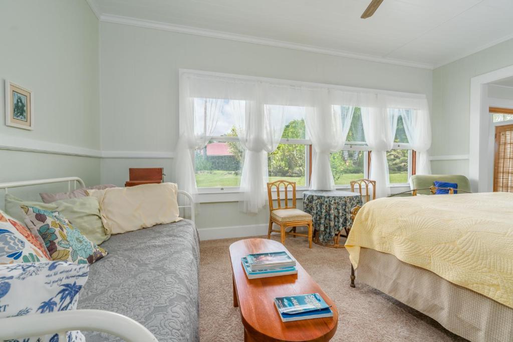a bedroom with a bed and a couch and a table at Old Hawaiian Bed and Breakfast in Hilo
