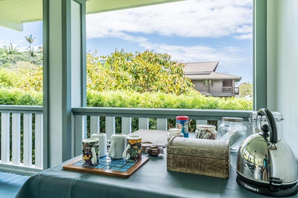 a table on a porch with a view of a window at Old Hawaiian Bed and Breakfast in Hilo