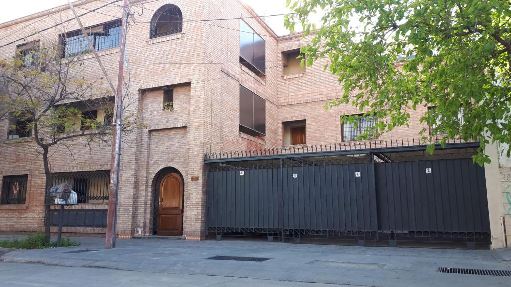 a large brick building with a black garage at Departamento a 100mts de los Portones del Parque in Mendoza