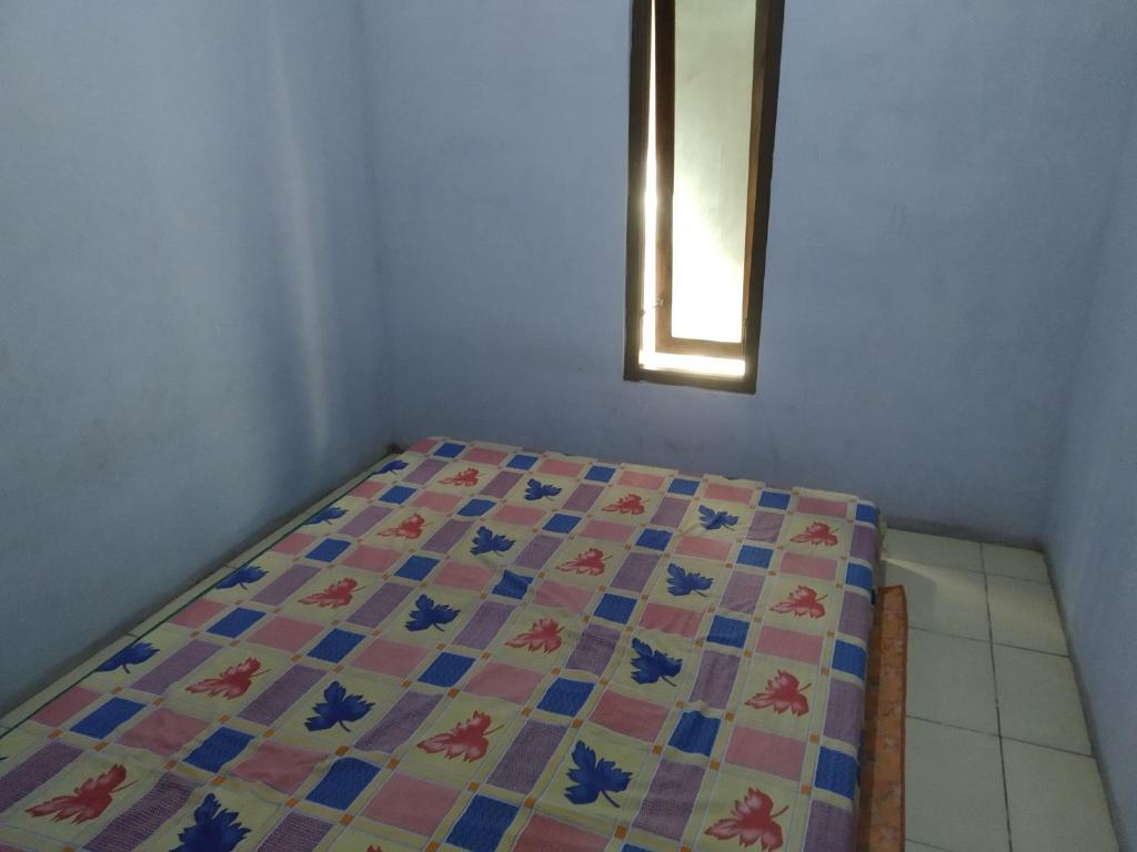 - une chambre avec un lit doté d'une couette dans l'établissement Homestay Banyumili, à Semigaluh