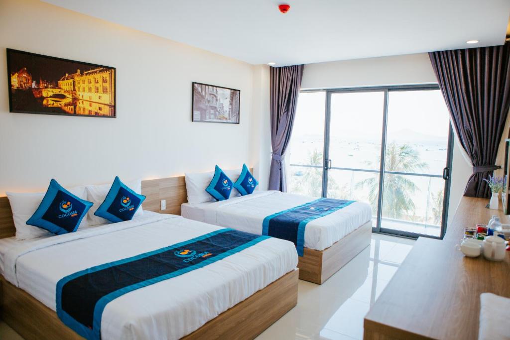 a hotel room with two beds and a window at COCOSEA HOTEL in Ðiệp Sơn