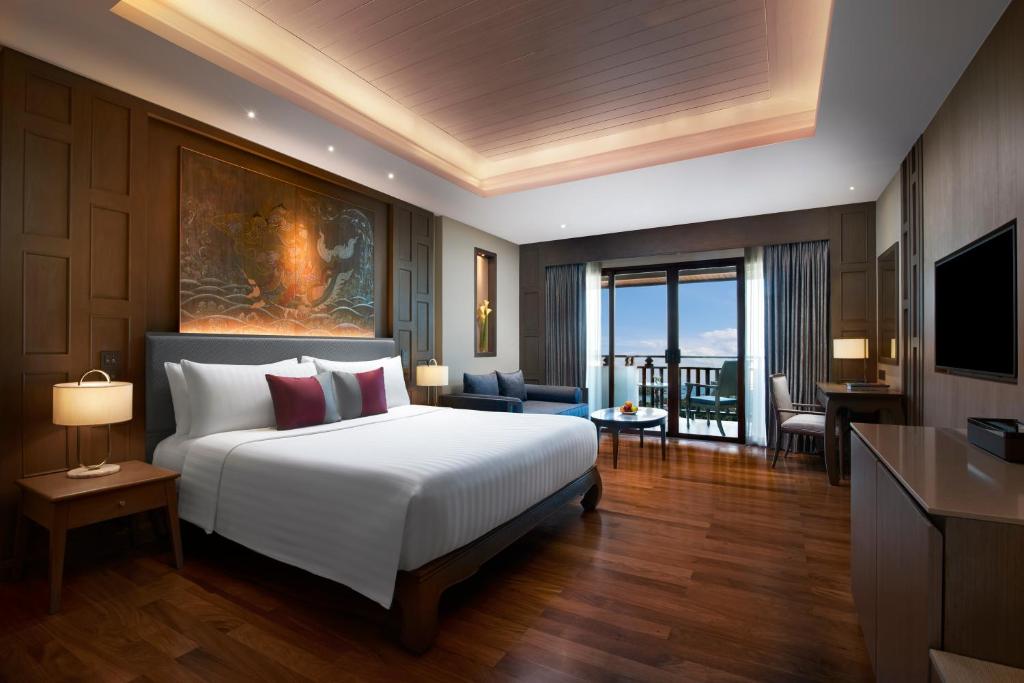a bedroom with a large bed and a living room at Amari Vogue Krabi in Tab Kaek Beach