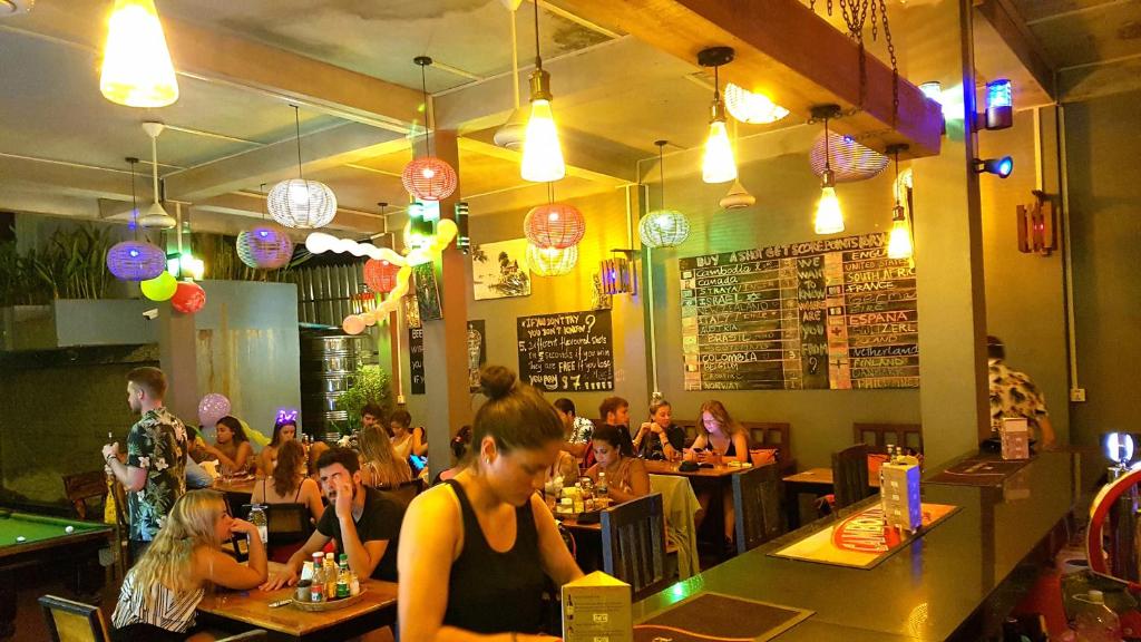 a group of people sitting in a restaurant at Siem Reap Pub Hostel in Siem Reap