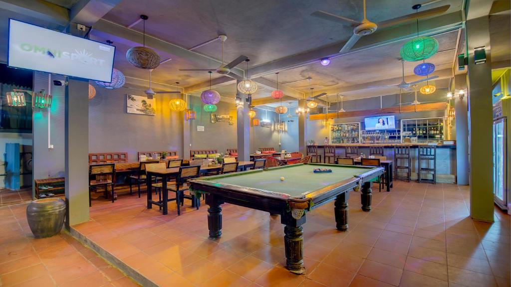 a pool table in a room with tables and chairs at Siem Reap Pub Hostel in Siem Reap